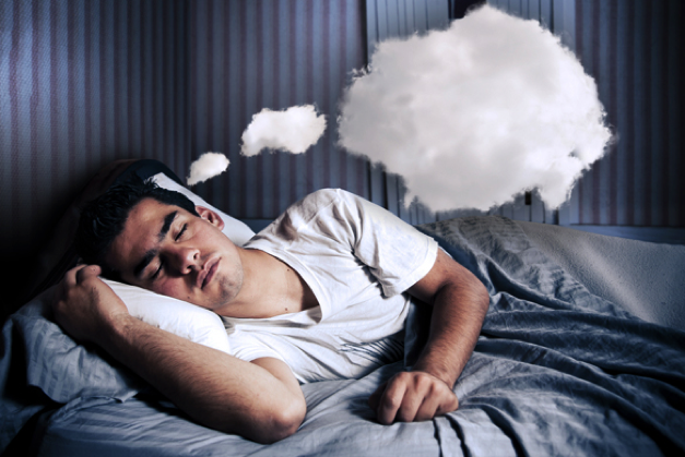 man sleeping in bed with dream cloud above his head